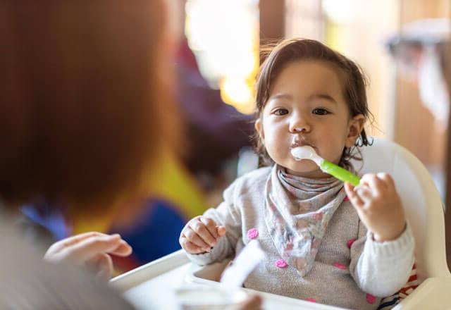 child eats yogurt with a spoon